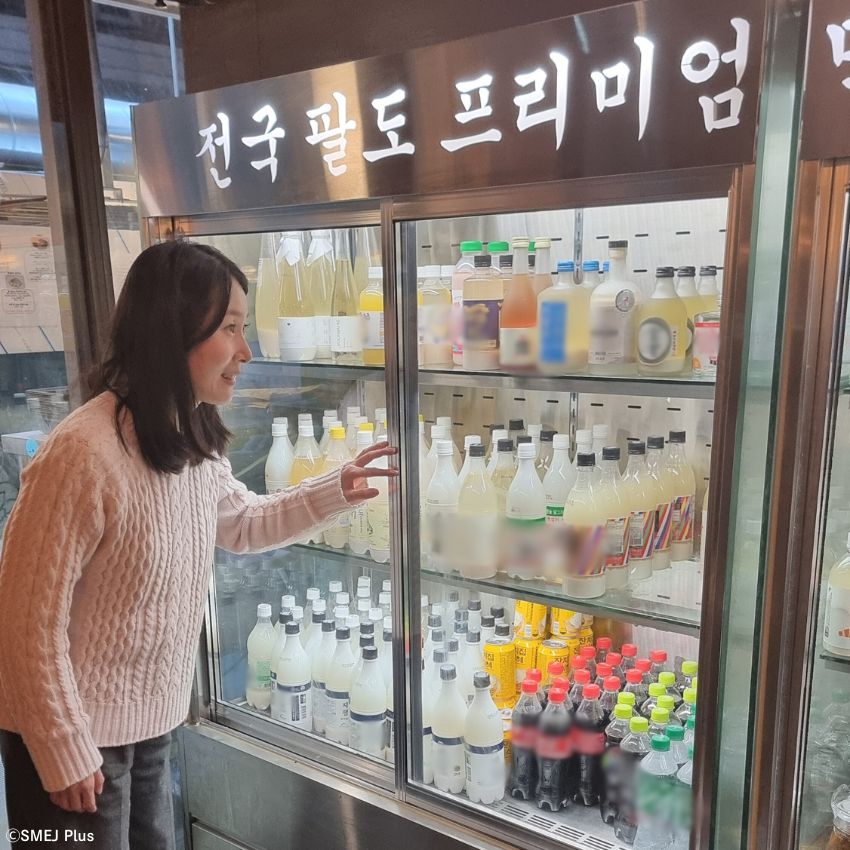 冷蔵庫に並ぶ全国の珍しいマッコリに目を輝かせる筆者