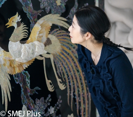 伝統工芸品を観察する仙道敦子さんの写真