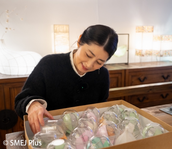 卓上ランプの韓紙の色を選んでいる仙道敦子さんの写真