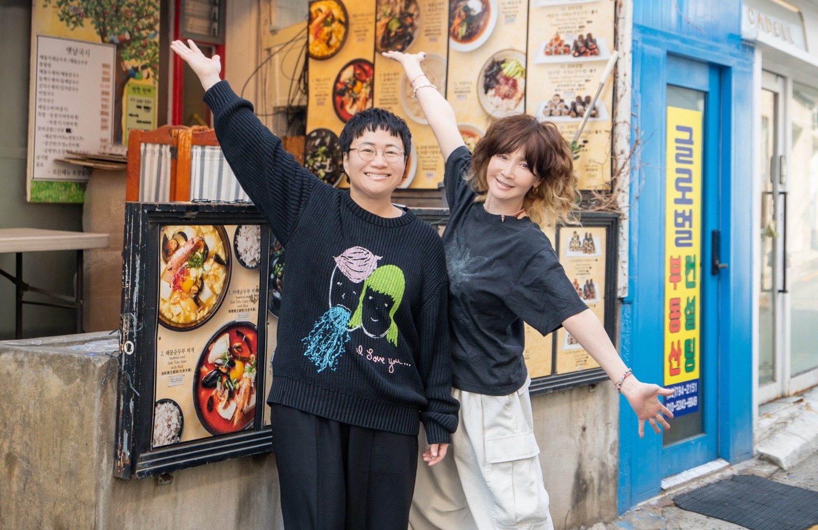옛날국시(イエナルグクス)の店前でポーズをとるYOUさんと近藤春菜さんの写真